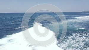 Aerial tracking shot of male surfer riding a big wave surfing in ocean on summer