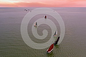 Aerial from traditional dutch wooden boats at the IJsselmeer near the harbor from Laaxum in Friesland the Netherlands at sunset,