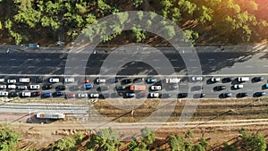 Aerial. Traffic jam with a lot of cars on a highway between forest. Peak hour. Top view