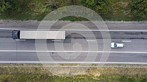 Aerial. Traffic by the rural highway. Sedan car and truck on the motorway. Top view