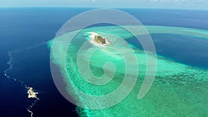 Aerial: tropical atoll view from above, blue lagoon turquoise water coral reef, Wakatobi Marine National Park, Indonesia - concept