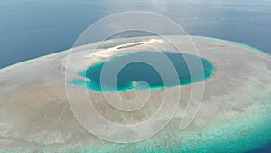 Aerial: tropical atoll view from above, blue lagoon turquoise water coral reef, Wakatobi Marine National Park, Indonesia - concept