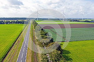 Aerial from a typical dutch landscape: straight roads, windmills and beautiful meadows in the Netherlands