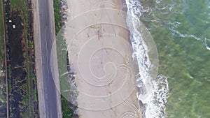 Aerial upside down view of sea coast and road with cars