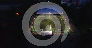 Aerial urban cityscape people training on football soccer pitch establishing shot 4K