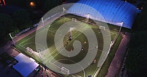 Aerial urban cityscape people training on football soccer pitch establishing shot 4K