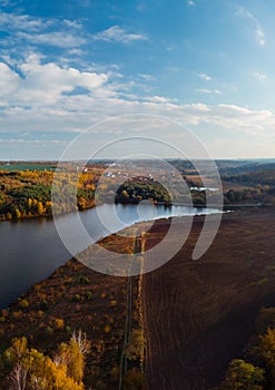 Aerial vertcal view of lake at sunrise in autumn. Meadows, trees at dawn. Colorful aerial landscape of river coast at sunset in