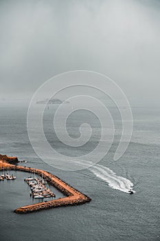 Aerial vertical view of boats at the harbor on a foggy day