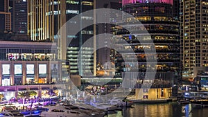 Aerial vew of Dubai Marina with shoping mall, restaurants, towers and yachts night timelapse, United Arab Emirates.