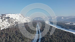 Aerial video of Altai country forest road on the bank of river Katun in winter. Altai, Siberia, Russia