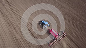 Aerial video of big tractor with cultivator ploughs field