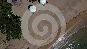 Aerial video of slowly moving on top view of traditional fisherman boats to beach umbrellas resort's area