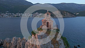 Aerial video. The Sveta Nedelja - Christian church on a tiny island in the sea close to the city of Petrovac Lots of