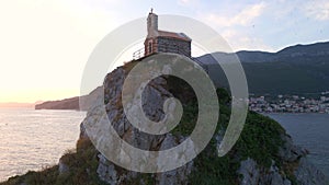 Aerial video. The Sveta Nedelja - Christian church on a tiny island in the sea close to the city of Petrovac Lots of