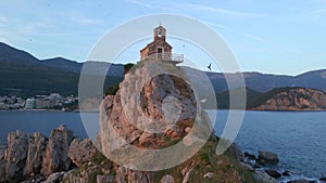 Aerial video. The Sveta Nedelja - Christian church on a tiny island in the sea close to the city of Petrovac Lots of