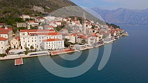 Aerial video. The view of the city of Perast. In the center of the city, the Bell Tower in the church of Saint Nikolas