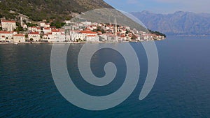 Aerial video. The view of the city of Perast. In the center of the city, the Bell Tower in the church of Saint Nikolas
