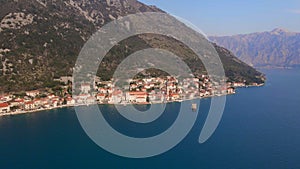 Aerial video. The view of the city of Perast. In the center of the city, the Bell Tower in the church of Saint Nikolas