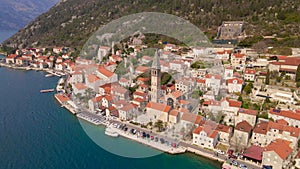 Aerial video. The view of the city of Perast. In the center of the city, the Bell Tower in the church of Saint Nikolas