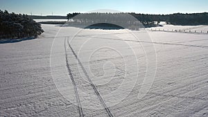 Aerial video view of a winter landscape in Europe, flying over snow covered meadows, fields and forests