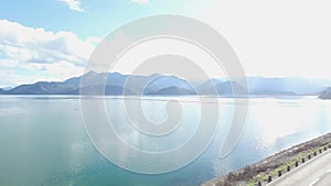 Aerial viev on landscape of sea shore and blue sky and mountains background. Footage. Aerial view of blue sky, sea and