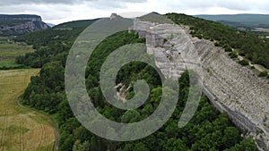 Aerial viev of lush green farm field with rocky cliffs in the distance. beauty of rural areas and the agricultural