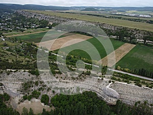 Aerial viev of lush green farm field with rocky cliffs in the distance. beauty of rural areas and the agricultural