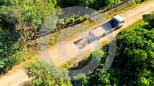 Aerial view of a 4x4 vehicle on a dirt road in a dense green forest.