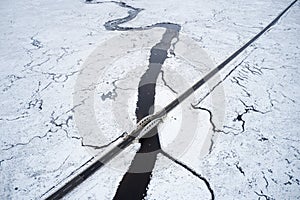 Aerial view of A82 road through Rannoch Moor and Black Mount covered in snow during winter