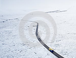 Aerial view of A82 road through Rannoch Moor and Black Mount covered in snow during winter