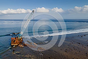 Aerial view of abandoned construction crane over the sea