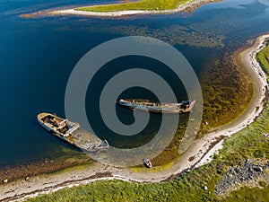 Aerial view of abandoned and derelict rusty old ships near lonaly island in The Arctic Ocean. Russia. White Sea