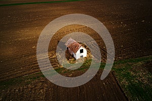 Aerial view of abandoned farmhouse in field, drone pov