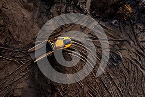 Aerial view above an earth mover truck on a muddy construction site