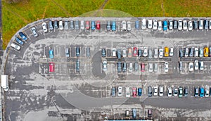 Aerial view from above of the parking lot with cars in the business district of the city, wet asphalt