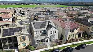 Aerial view above residential neighborhood houses, solar renewable energy panels