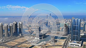 Aerial view of Abu Dhabi city skyline, famous towers and skyscrapers surrounded by fog clouds in the morning