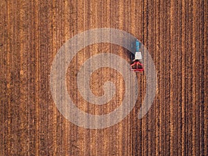 Aerial view of agricultural tractor doing stubble tillage