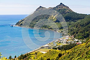 Aerial view of Ahurei village and bay. Unloading ship in the port. Rapa Iti island, Bass/Austral/Tubuai Islands, French Polynesia.