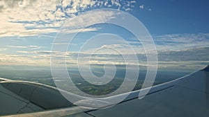 Aerial view from aircraft window on big steel wing fly above summer landscape