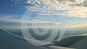 Aerial view from aircraft window on big steel wing fly above summer landscape