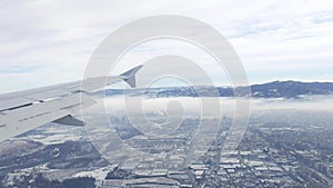 Aerial view from airplane. Flying over hill range with mist and fog in winter time, landscape, Italy