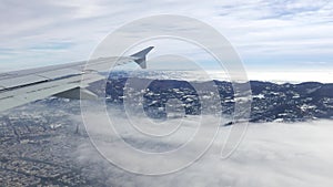 Aerial view from airplane. Flying over hill range with mist and fog in winter time, landscape, Italy