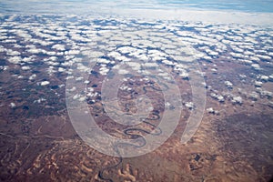 Aerial view from airplane during international flight. Travel in airplane, landscape from above and clouds