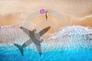 Aerial view of airplane shadow, woman, swim ring, beach, sea