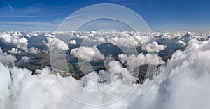 Aerial view from airplane window at high altitude of earth covered with white puffy cumulus clouds