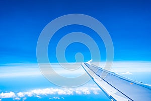 Aerial view of airplane wing with blue sky