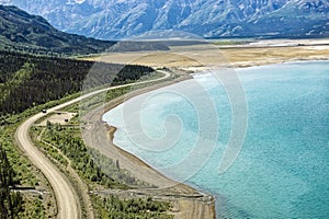 An aerial view of the Alaska Highway curving along Kluane Lake in the Yukon Territory, Canada