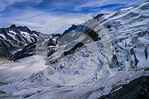 Aerial view of the Alps mountains in Switzerland. View from helicopter in Swiss Alps. Mountain tops in snow.