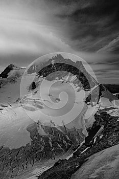 Aerial view of the Alps mountains in Switzerland. View from helicopter in Swiss Alps. Mountain tops in snow.